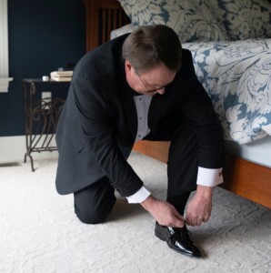 James tying his shoe for a wedding after getting relief from severe lower back pain